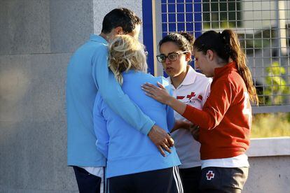 Personal de la Cruz Roja habla con unos familiares de los fallecidos en el accidente del minibús, en el Instituto de Medicina Legal de Badajoz.