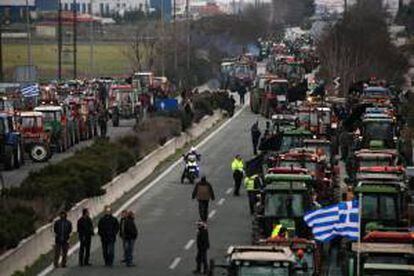 Agricultores griegos permanecen junto a tractores bloqueando una vía que conecta a Atenas con Salónica en Níkea, Grecia. EFE/Archivo