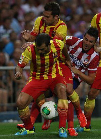 Mascherano protege el balón ante Jordi Alba y Villa.