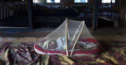 Un niño sufriendo de malnutrición protegido por una mosquitera en el sur de Sudán.