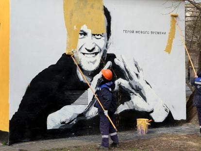 Empleados municipales pintan sobre un mural con el retrato de Navalni, el pasado abril en San Petersburgo.