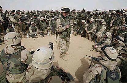 Un capitán habla con los soldados en el desierto de Kuwait.