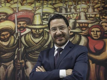 Mart&iacute; Batres frente a una reproducci&oacute;n de un mural de Siqueiros. 