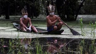 Satere-mawe indigenous men navigate the Ariau river during the COVID-19 novel coronavirus pandemic at the Sahu-Ape community, 80 km of Manaus, Amazonas State, Brazil, on May 5, 2020. - The Brazilian state of Amazonas, home to most of the country's indigenous people, is one of the regions worst affected by the pandemic, with more than 500 deaths to date according to the health ministry. (Photo by RICARDO OLIVEIRA / AFP)