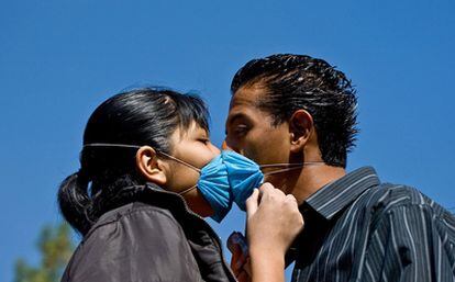 Una pareja se besa en Ciudad de México en abril de 2009, durante la pandemia por la gripe A.