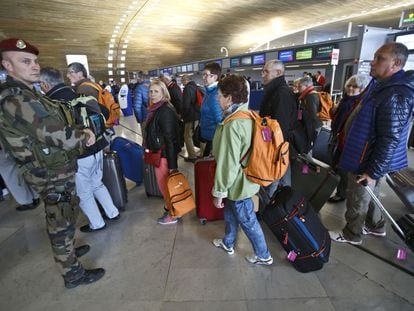 Diversos passatgers i un soldat francès a l'aeroport Charles de Gaulle, on roman el menor.