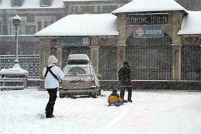Una familia se divierte ayer en la nieve frente a la Estación de Ferrocarril de Canfranc, Huesca.