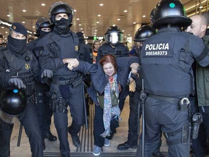 Los Mossos desalojan a una mujer de la estación de Sants de Barcelona, este sábado.