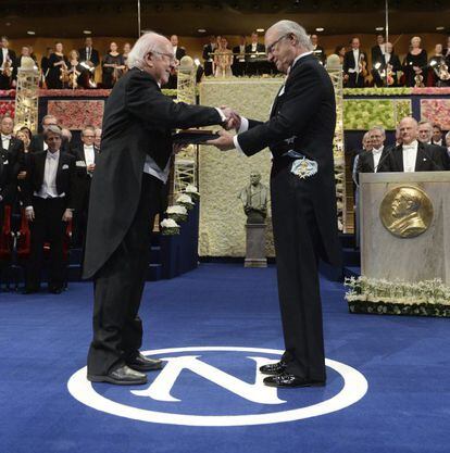 El premio Nobel de Física Peter W. Higgs (i) recibe su galardón de manos del rey Carlos XVI Gustavo de Suecia.
