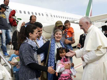 Los refugiados saludan al Pontífice a su llegada al aeropuerto de Roma.