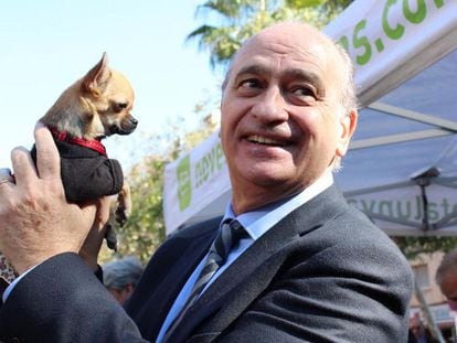 Jorge Fernández Díaz, exministro del Interior, bromea con una perrita en una campaña electoral, en 2011.