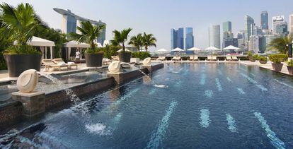 La piscina de 25 metros del hotel Mandarin Oriental Singapur, rodeada de un frondoso paisaje tropical.