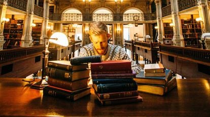 Un hombre estudia en una biblioteca.