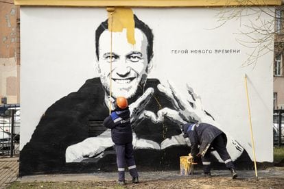 Trabajadores municipales tapan un mural con el retrato del activista y el lema "Héroe de nuestro tiempo", que apareció el jueves en la pared de un edificio de San Petersburgo. 