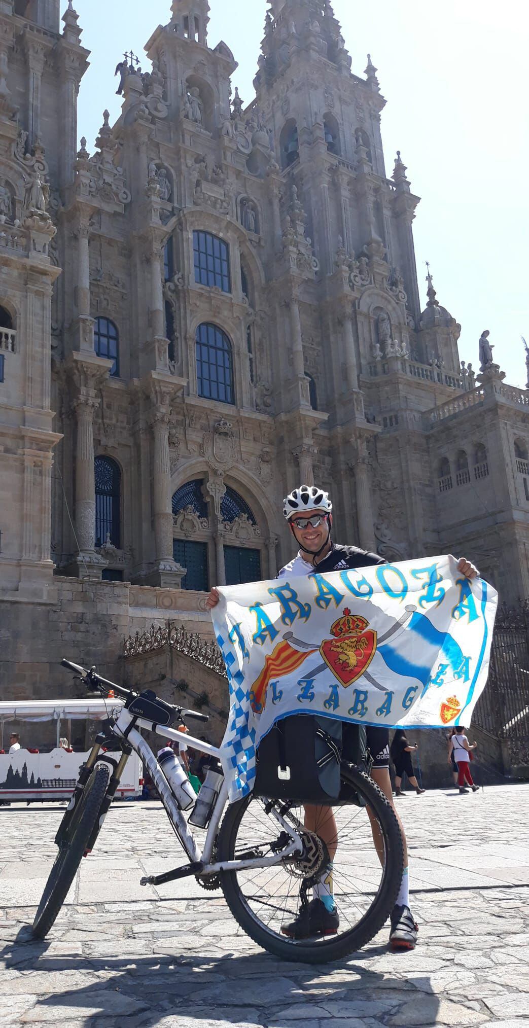 Miguel Cardiel con la bandera del Zaragoza frente a la catedral de Santiago de Compostela tras completar un tramo del Camino de Santiago.