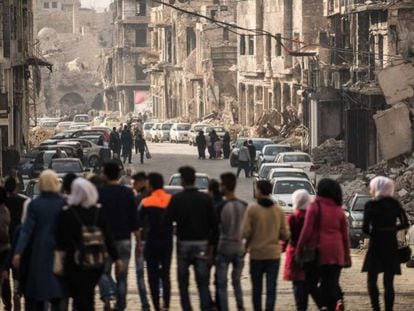 Un grupo de personas camina por una calle de Alepo./ En vídeo, un analista advierte del riesgo de una rápida retirada de las tropas estadounidenses en Siria.