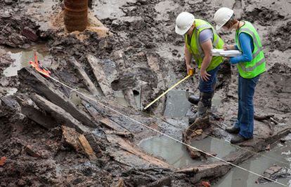 Unos arqueólogos miden los restos del buque del siglo XVIII hallado en la <i>Zona Cero</i> .