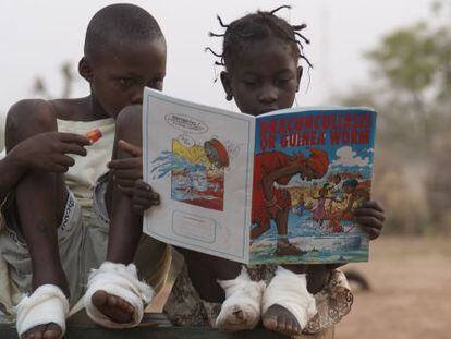 Fatawu Yakubu (izquierda) y Sadia Mesuna leen un c&oacute;mic sobre el gusano de Guinea en un centro de pacientes en Ghana, en 2007. 