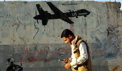 Un yemení pasa frente a un graffiti contrario a los bombardeos estadounidenses en el país.
