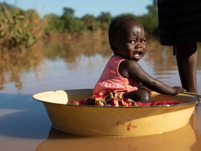 Una madre baña a su hija en agua estancada producto de las inundaciones del ciclón Idai en Matarara (Mozambique).