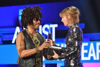 Taylor Swift recoge el premio como Artista del Año de manos de Lenny Kravitz.