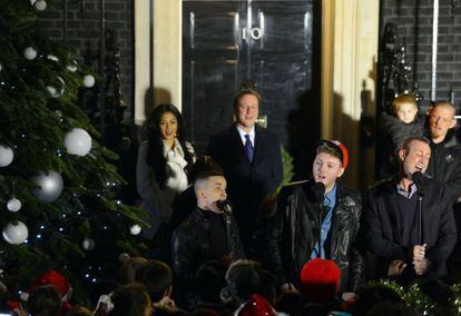 El primer ministro David Cameron (centro) minutos antes de encender el árbol de navidad frente a Downing Street 10, su residencia oficial.