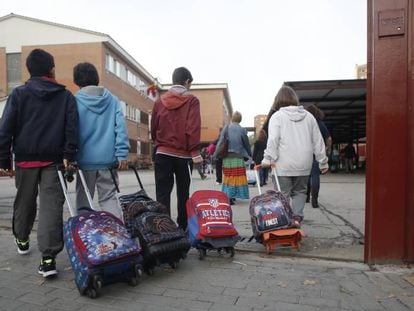 Varios niños entran en el colegio público La Latina en Aluche.