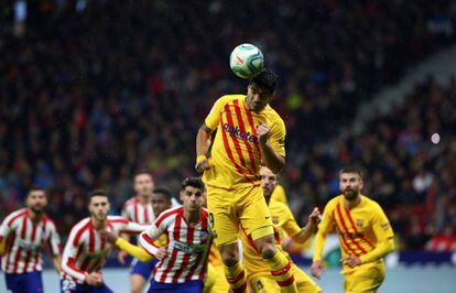 Luis Suárez cabecea un balón ante la defensa del Alético.