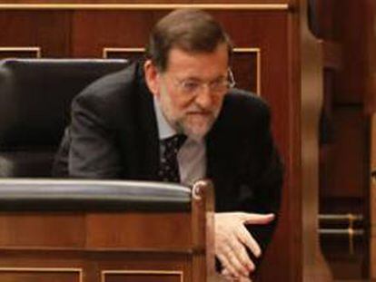El presidente del Gobierno, Mariano Rajoy, saluda a Cristóbal Montoro en presencia de Soraya Sáenz de Santamaría en el debate sobre los presupuestos generales del Estado 2013