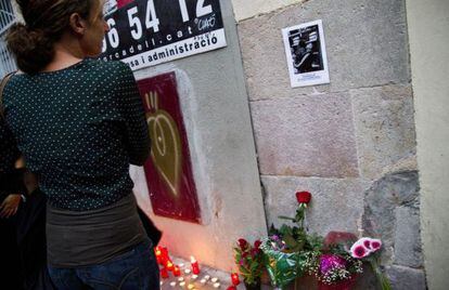 Una mujer mira la foto de Benítez, frente a su casa.