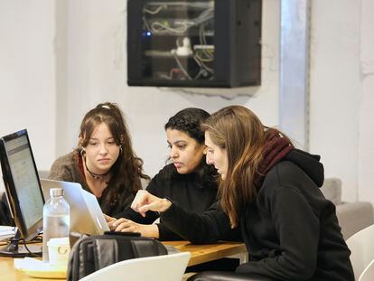 Tres estudiantes de Programación trabajan junto a un ordenador en la sede de Barcelona.
