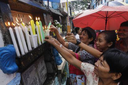 Filipinos encienden velas durante una visita al cementerio público de Quezón en Manila (Filipinas), el 1 de noviembre de 2017.