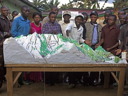 El maestro pigmeo Irangi (en el centro) muestra un mapa tridimensional de su zona en la Reserva de Itombwe, en RDC.