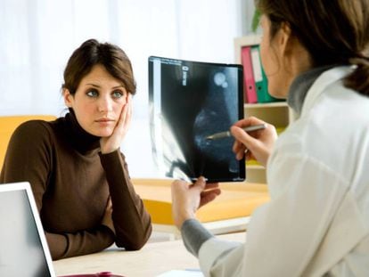 Doctora examina la mamografía de una paciente.