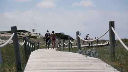 Dos bañistas caminan por la playa de Ses Illetes, Formentera.