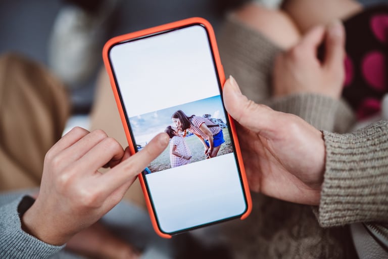 Un teléfono muestra la imagen de una madre con su hija.