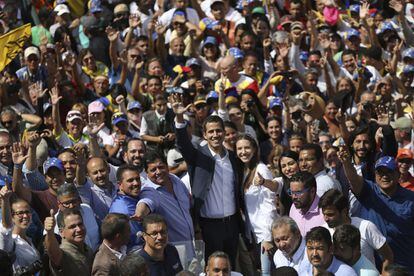 Juan Guaidó, quien se ha declarado presidente interino de Venezuela, saluda durante una manifestación que exige la renuncia del líder chavista Nicolás Maduro, en la capital del país, el 2 de febrero de 2019. Guaidó está acompañado por su esposa Fabiana Rosales.