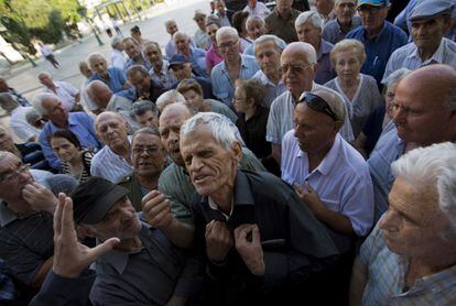 Un grupo de pensionistas discuten con un trabajador de una sucursarl bancaria en Atenas, Grecia. 