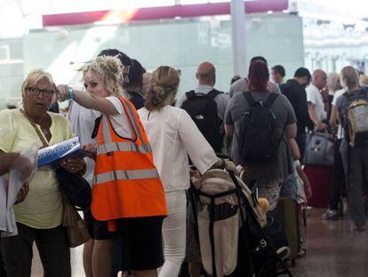 Una treballadora d'Aena informant viatgers a l'aeroport del Prat.