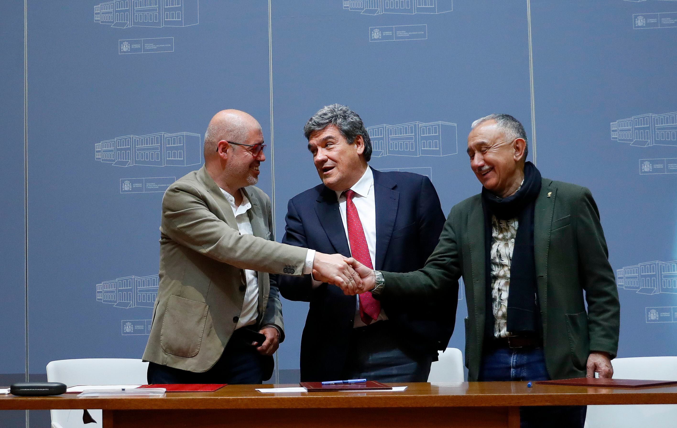 Unai Sordo (CCOO), el ministro Escrivá y Pepe Álvarez (UGT) se saludan tras la firma de acuerdo sobre pensiones este miércoles en Madrid. 