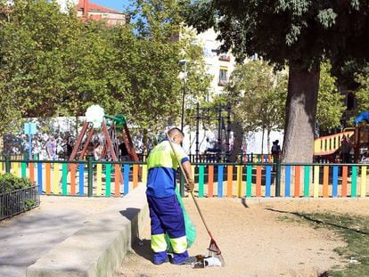 Un barrendero limpia al sol en el parque del Casino de la Reina, en Lavapiés, Madrid.