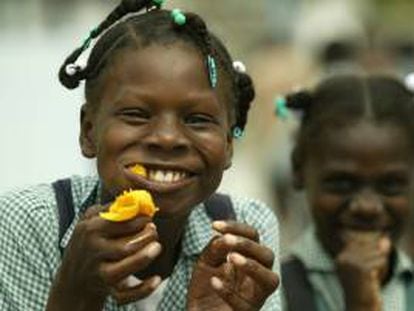 Una niña come mango en el sector de Cite Soleil en Puerto Príncipe (Haití). EFE/Archivo