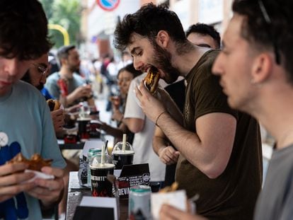 Varias personas comen hamburguesas en el restaurante de comida rápida Meat Crew el 28 de mayo de 2023 en Milán.