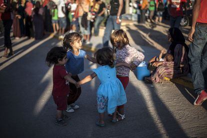 Unos niños, residentes del CETI, juegan al corro a las puertas del centro. De los 1600 inquilinos, unos 400 son menores.