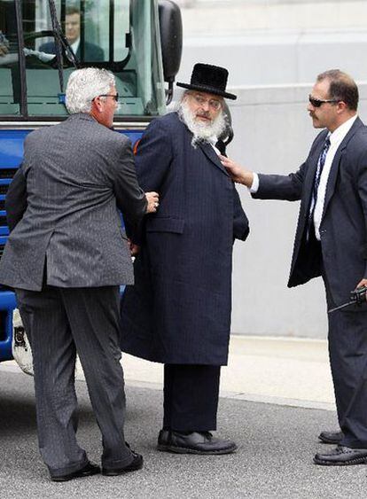 Dos agentes del FBI acompañan a un rabino esposado en Newark, Nueva Jersey.
