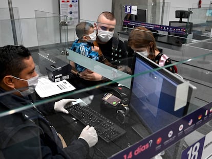 Viajeros con mascarillas en el aeropuerto de Bogotá. En vídeo, el anuncio del cierre de fronteras de los tres países.