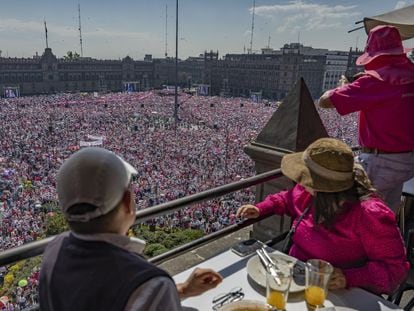 Personas miran la manifestación a favor del INE en la plancha del Zócalo desde una terraza, el 26 de febrero.
