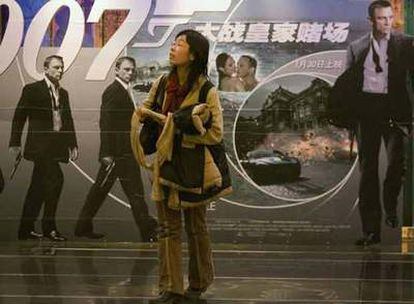 Una mujer china pasa por delante de uno de los carteles promocionales de la película <i>Casino Royal</i>. Por primera vez en 45 años, una de las películas de la saga de James Bond ha pasado la censura en este país y podrá ser exhibida en los cines. El estreno en Pekín, con la asistencia de los actores, promete ser uno de los eventos más &#39;glamourosos&#39; en la historia de China.