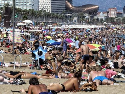 Turistas y vecinos en la playa de la Barceloneta, en Barcelona.  