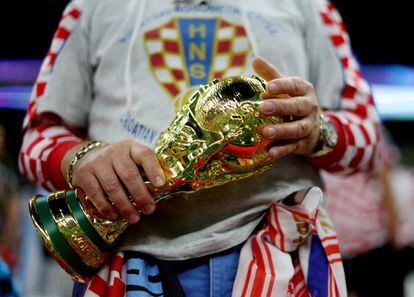 Un aficionado croata sostiene una réplica de la copa del mundo en las gradas del estadio Lusail de Qatar. 